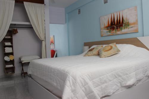 une chambre avec un grand lit avec des draps blancs dans l'établissement Casa Iliria Apartments walking distance to Boquerón, à Boqueron