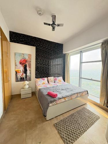 a bedroom with a bed and a large window at Spectrum Metro Mall 1bhk With Swimming Apartment Sector 75 Noida in Noida