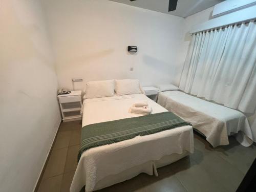 ein Schlafzimmer mit zwei Betten und einem Fenster in der Unterkunft Hotel Artico in Mar del Plata