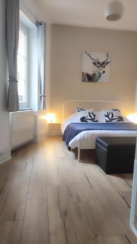 een slaapkamer met een bed en een houten vloer bij Strasbourg - Deux Chambres & Garage in Straatsburg