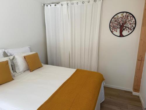 a bedroom with a bed with a tree picture on the wall at Studio neuf dans un espace boisé in Locronan