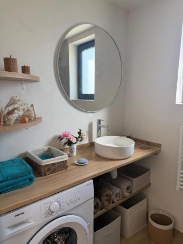 a bathroom with a washing machine and a mirror at Studio neuf dans un espace boisé in Locronan