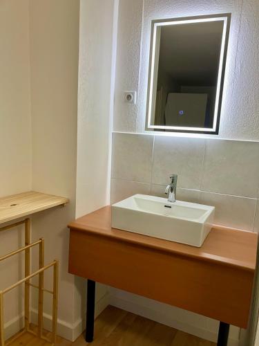 un bagno con lavandino bianco e specchio di Gîte Orchidée a Ergersheim