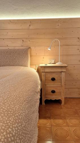 a bedroom with a bed and a lamp on a night stand at Da Nonna Isa - Ampio appartamento tra Bormio e Bernina Express in Grosotto