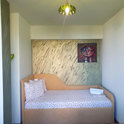 a bed in a room with a painting on the wall at Yantra Tower Deluxe in Gabrovo