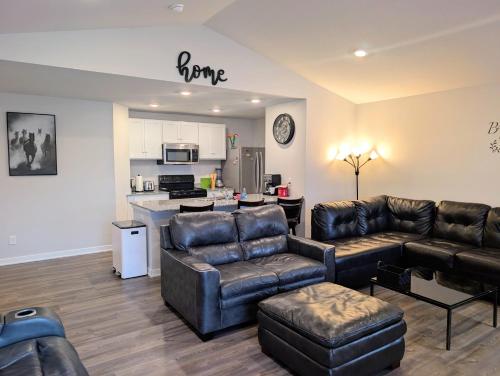 a living room with leather furniture and a kitchen at Modern Comfort in Des Moines