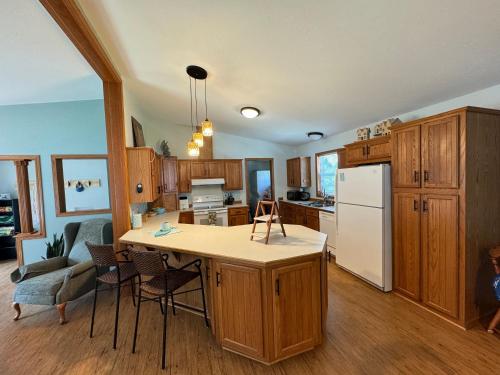 a kitchen with wooden cabinets and a white refrigerator at Legacy Lakehouse in Spicer