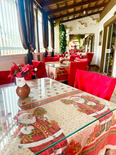 een eetkamer met een tafel en rode stoelen bij Pousada Alegria do Cowboy in Penha