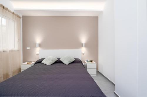 ein Schlafzimmer mit einem großen Bett mit zwei Nachttischen in der Unterkunft GiuMar Apartments Aci Trezza in Aci Catena