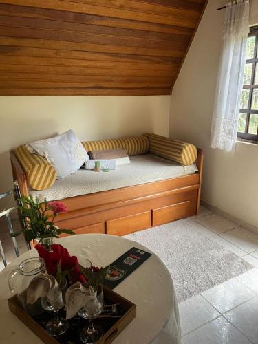 a bed in a room with a table in a room at Espaço Benviver in Guaratinguetá