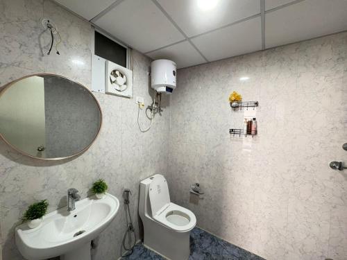 a bathroom with a sink and a toilet and a mirror at 1bhk Apartment With Swimming Sector 75 Noida in Noida