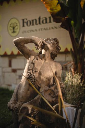 a statue of a woman sitting next to a plant at Casa Fontana in Alaçatı