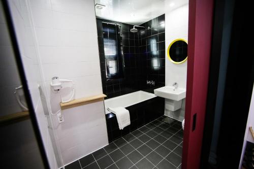 a bathroom with a sink and a bath tub at Boutique Hotel Wine in Gwangju