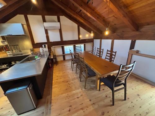 a kitchen and dining room with a wooden table and chairs at 離れの宿 かぶろの庭 離れの宿 KuRA in Matsukawa