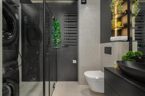 ein Badezimmer mit Toilette, Waschbecken und Waschmaschine in der Unterkunft Apartment Sea Light - Best Comfort - by rentmonkey in Pogorzelica