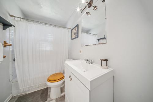 a white bathroom with a toilet and a sink at Cozy two bedroom one bath in Cleveland