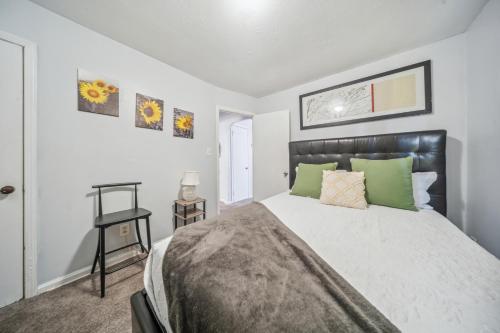 a bedroom with a large bed with green pillows at Cozy two bedroom one bath in Cleveland