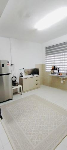 a kitchen with a refrigerator and a white floor at HomestayFA in Gua Sai