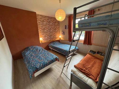 ein Zimmer mit zwei Etagenbetten und einem Bett in der Unterkunft Gîte du Tilleul - un petit coin de nature in Vallet