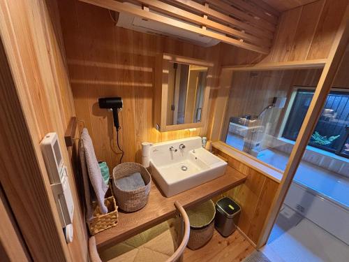 a bathroom with a sink and a mirror at 離れの宿 かぶろの庭 in Matsukawa