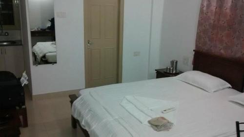 a bedroom with a bed with a towel on it at Hotel Grande Inn in Udaipur