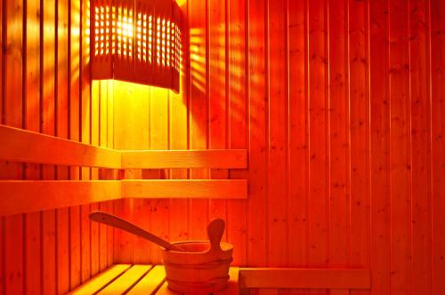 a sauna with a wooden wall with a wooden spoon in it at Aqua Hotel in Burgas City