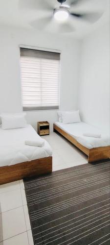 two beds in a room with a window at HomestayFA in Gua Sai