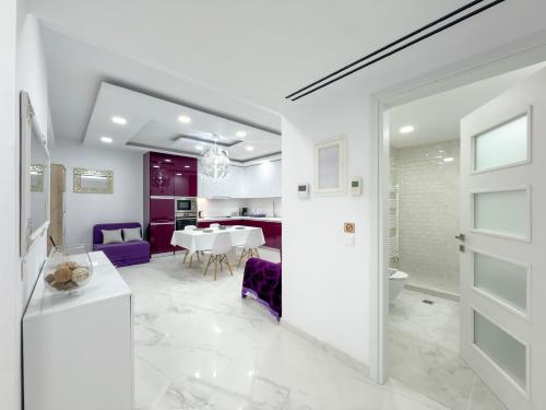 eine weiße Küche und ein weißes Esszimmer mit einer weißen Tür in der Unterkunft Diamond Luxury Villa Corfu in Káto Spílaion