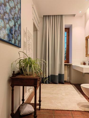a bathroom with a table with a plant on it at BotanicaSuiteTorino in Baldissero Torinese