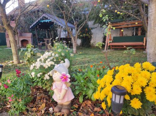 a small figurine in a garden with flowers at Little Bear Busteni 3 in Buşteni