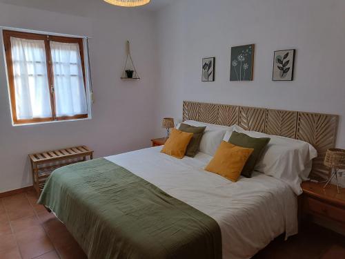 une chambre avec un grand lit avec des oreillers jaunes dans l'établissement Casa Caldereta, à Ayelo de Rugat