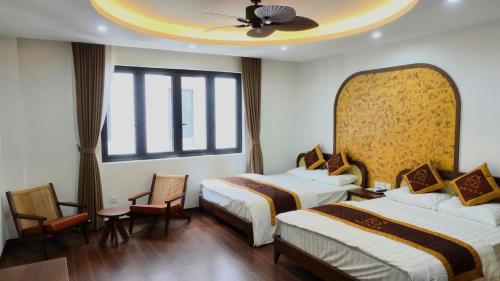 a hotel room with two beds and a ceiling at Maison Homestay Pho Bien 17, Ocean Park 3 in Ðình Loan