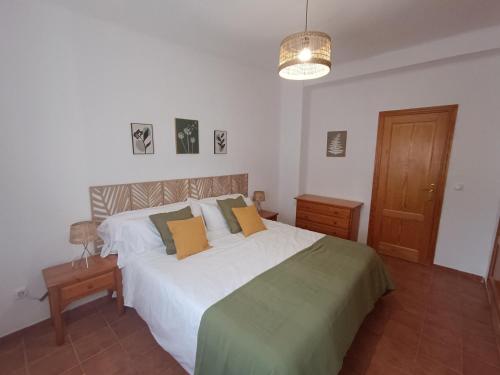 une chambre avec un grand lit blanc avec des oreillers orange dans l'établissement Casa Caldereta, à Ayelo de Rugat