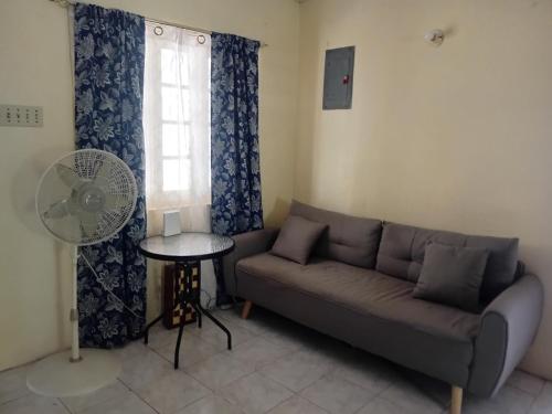 a living room with a couch and a fan at Nature Lodge Retreat in Portland in Port Antonio