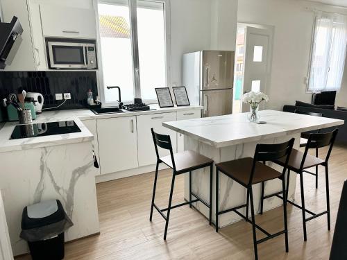 eine Küche mit einem weißen Tisch und Stühlen in der Unterkunft Grand Studio WiFi rapide RER B in Sevran