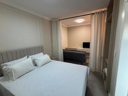 伊瓜苏Ravello Residencial - Próximo ao Paraguai e Centro de Foz do Iguaçu的卧室里有一张床，床单和枕头都是白色的