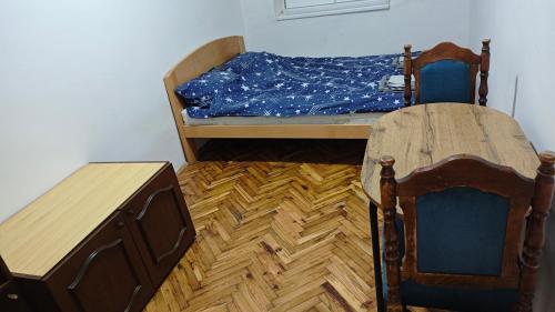 a small bedroom with a bed and a table at hometown in Pančevo