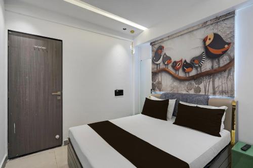 a bedroom with a bed with a painting on the wall at Hotel O Royal Fourtune in Surat