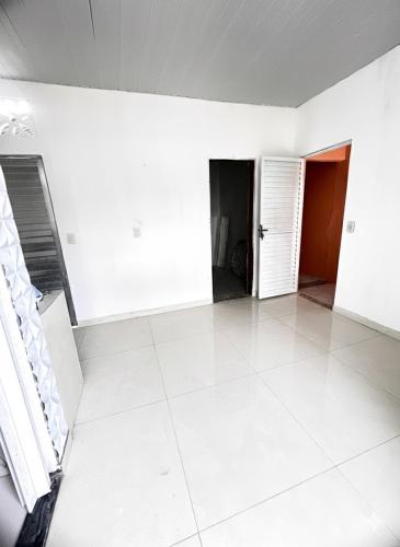 Cette chambre vide est dotée de murs blancs et de carrelage blanc. dans l'établissement Apartamento mobiliado - Próximo ao Estádio Olímpico do Mangueirão, à Belém