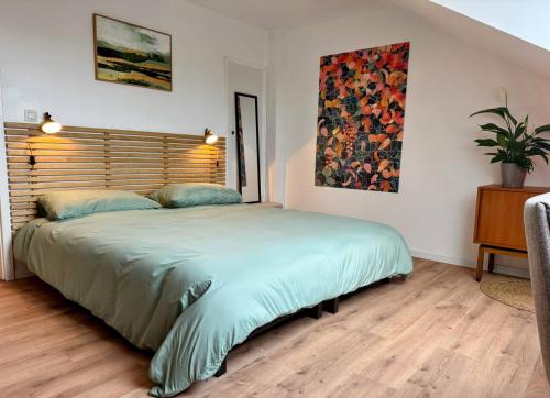 a bedroom with a large bed with a wooden headboard at Le BrasÔvert in Bras