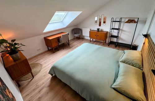 Schlafzimmer mit einem Bett, einem Schreibtisch und einem Dachfenster in der Unterkunft Le BrasÔvert in Bras