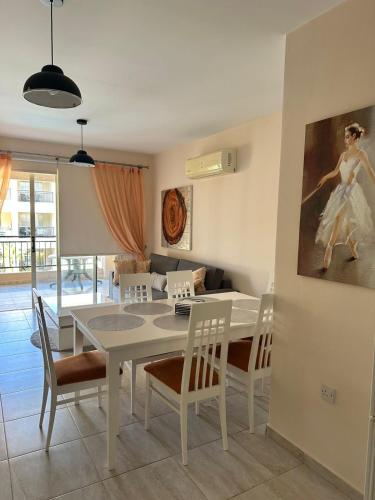 een eetkamer met een witte tafel en stoelen bij Royal Seacrest F 103 in Paphos City