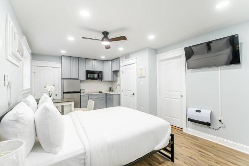a white bedroom with a white bed and a kitchen at Studio Minutes from Center City South Philly Special in Philadelphia