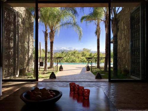 un bol de fruta sentado en una mesa frente a una puerta en Villa Dar Waw Marrakech, en Tameslouht