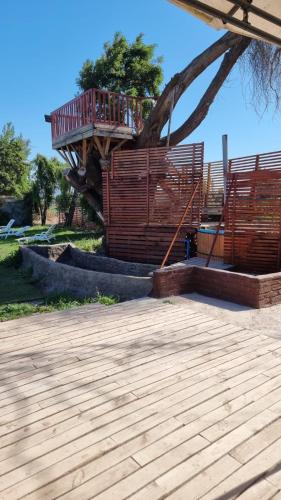 een speeltuin met een houten dek en een hek bij Cabañas Venecia in El Monte
