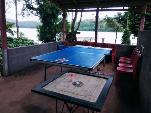 a blue ping pong table in a patio with a table at Finca Backwater Homestay in Suntikoppa