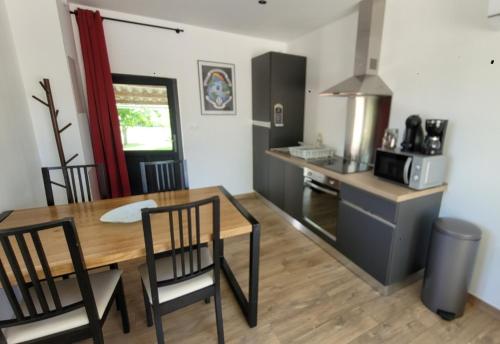 een keuken en eetkamer met een tafel en stoelen bij Gîte de la Côte Rouge in Saint-Nauphary