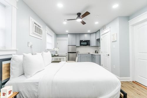 a white bedroom with a white bed and a kitchen at Studio Minutes from Center City South Philly Special in Philadelphia