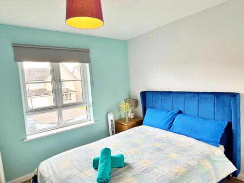 a blue bedroom with a bed with a blue head board at Newbuild - 3 bedrooms, 2 baths,5 mins from airport in Edinburgh