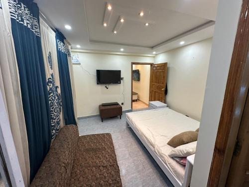 a small bedroom with a bed and a television at Mini cinema 1 bed Apartment Al Qamar Heights in Murree